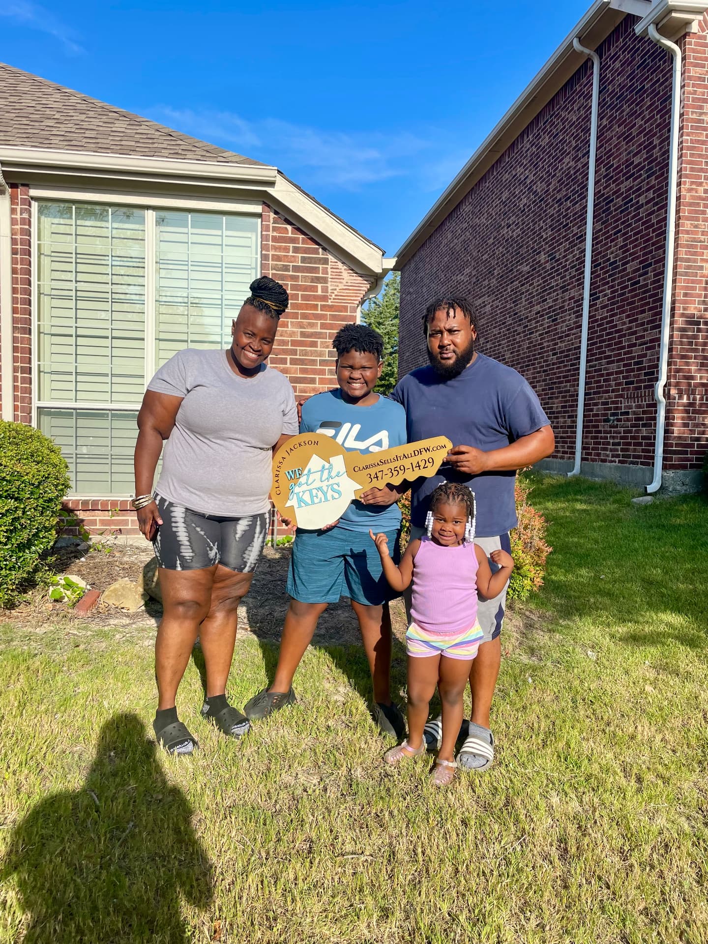 Family celebrating new home keys outside their home